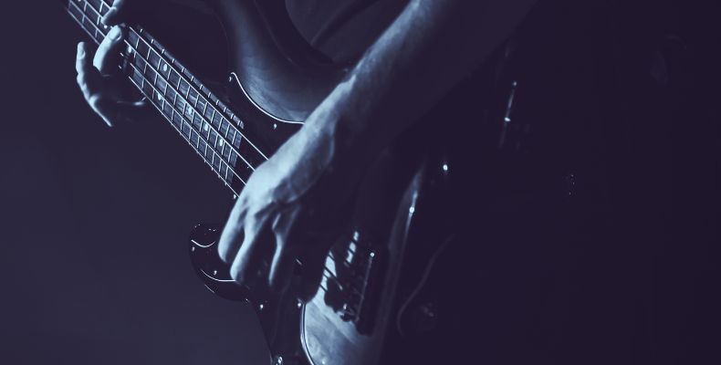 A bassist playing his bass, probably practicing some of the Best Easy Bass Guitar Songs For Beginners