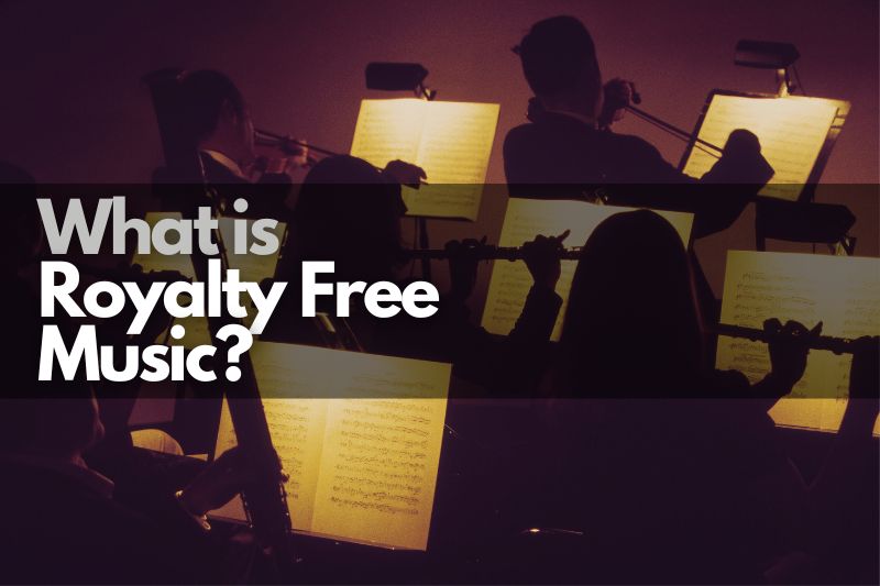 What Is Royalty Free Music: An orchesttra performing on a dark stage with lights shining down on their sheet music.