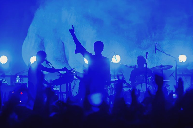 a band playing their instruments on a stage, performing to an audience