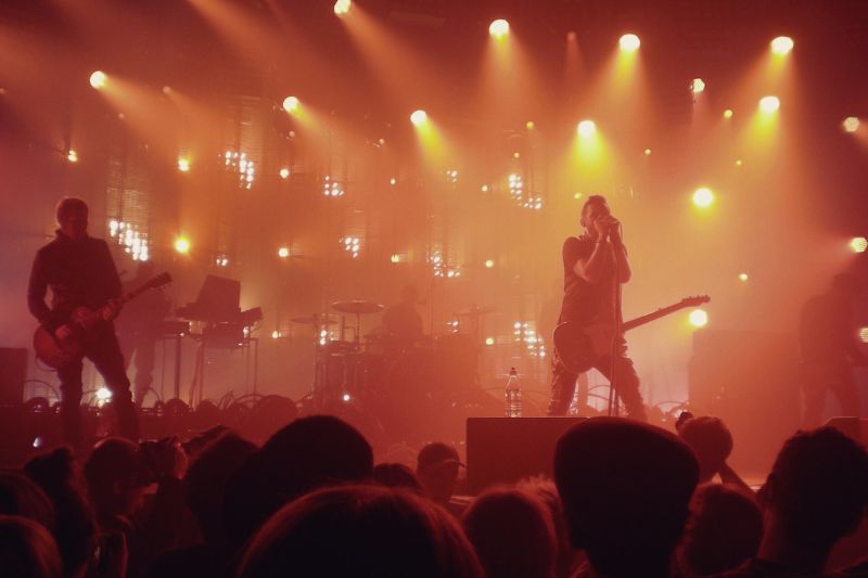 A band on a stage with a guitar and a crowd of people