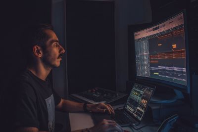Home Studio Setup: a producer sitting at a desk with a computer in his home studio