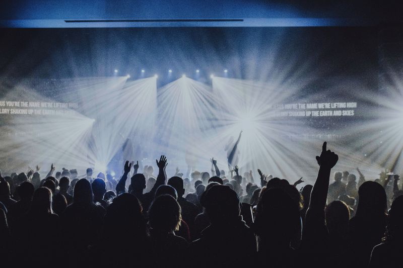 Dynamics In Music: A silhouette of a large audience in front of a stage with an artist performing.