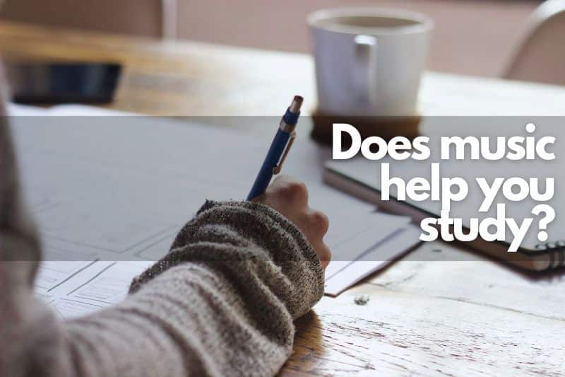 Does music help you study? A student sitting at their desk with a cup of coffee, pen and paper studying.