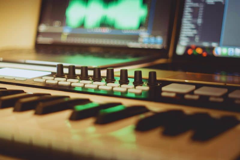 What is drill music? A music keyboard and computer screens visible in a recording studio.