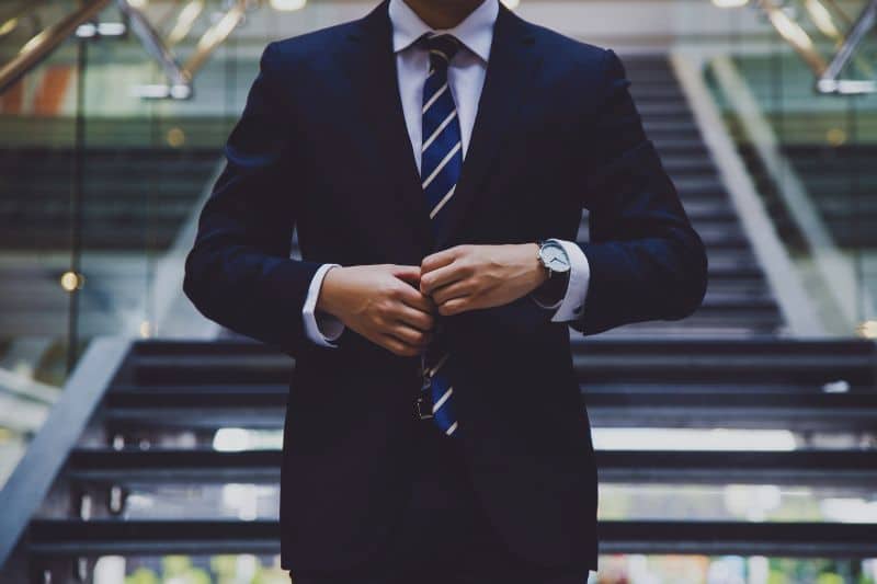A lawyer wearing a suit standing on some stairs.