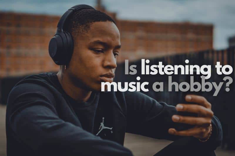 Is listening to music a hobby? A man sitting down outside, listening to music off of his phone on headphones.